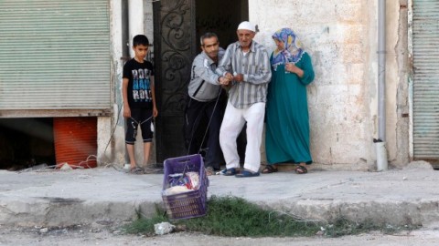 صورة لعائلة تسحب الطعام الذي يقدمه لها ناشطون في حي الأشرفية في حلب، خوفا من القناص. المصدر: الصورة للمصور مظفر سلميان نقلا عن رويترز
