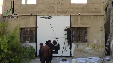 الناشطون أثناء رسمهم الجدارية. المصدر: الصفحة الرسمية لصامدون على الفيسبوك