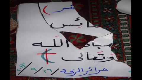 اللافتة التي مزقها عناصر داعش، وهي لافتة كتبتها سعاد تضامنا مع المسيحيين بعد إنزال داعش للصليب عن الكنيسة. المصدر: الصفحة الرسمية لسعاد على الفيسبوك