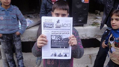 صورة تظهرُ طفلاً يحمل جريدة عنب بلدي، المصدر: جريدة السفير العربي