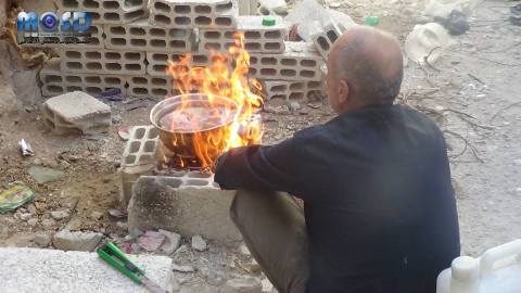 صورة لرجل وهو يطهو القطة. المصدر: صفحة مكتب جنوب دمشق الإعلامي على الفيسبوك