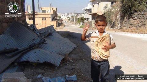 صورة طفل يحمل خبز في ريف دمشق، المصدر الصفحة الرسمية للفعالية عالفيسبوك.