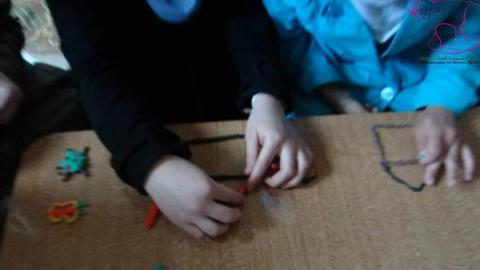 أيادي أطفال وهي تصنع أشكال من المعجون في دورة التفريغ النفسي في المليحة. المصدر: الصفحة الرسمية للمنظمة السورية للمرأة والطفل على الفيسبوك