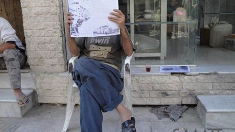 أحد المواطنين في مدينة كفر بطنا بريف دمشق يقرأ ضوضاء وهو يغطي وجهه بها كي لا تعرفه أجهزة الأمن. المصدر: الصفحة الرسمية للمجلة على الفيسبوك