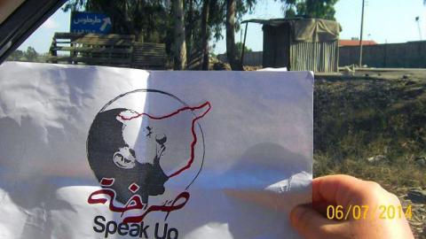 An activists holds a leaflet with The Cry's logo. Source: the group's Facebook page.