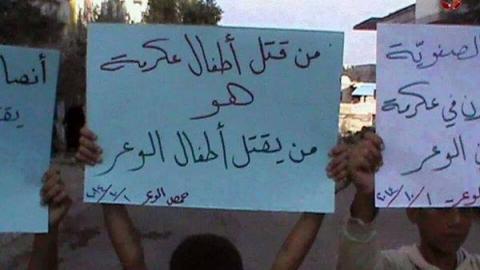 لافتات رفعها أطفال حي الوعر المحاصر في حمص تضامنا مع أطفال عكرمة. المصدر: صفحة الثورة السورية على الفيسبوك