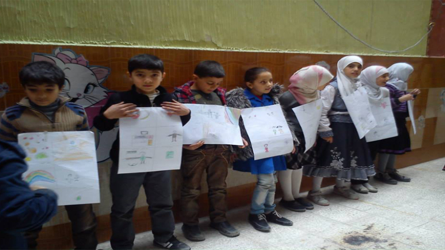 أطفال يحملون رسوماتهم في أحد نشاطات شبكة حراس في الغوطة. المصدر: شبكة حراس