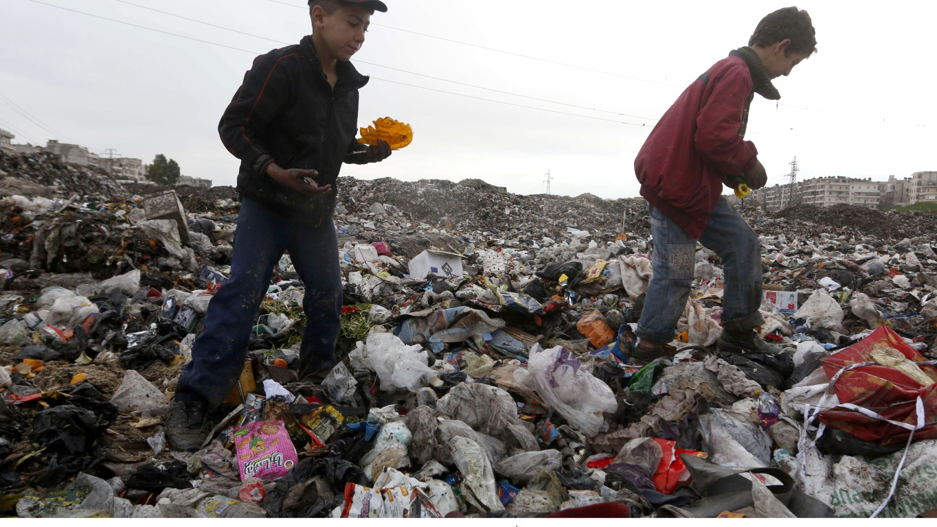 محمد وعبد الله يجمعان المواد الصالحة للبيع من القمامة. المصدر الإنسان في سوريا