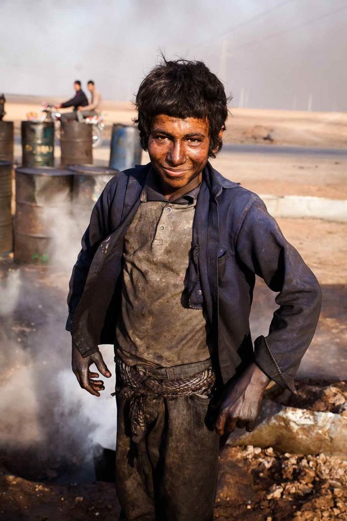 The Chilld Oil: Young boy working at makeshift oil refinery in Hasakah, Syria, 2014 ©Yann Renoult/Wostok Press