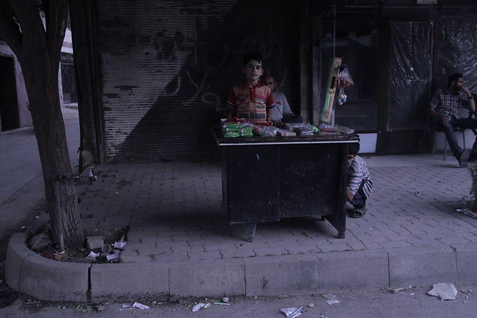 [Photo: A child-merchant in al-Qabun - Damascus - Ramadan (June 6 - July 5) 2016 (SyriaUntold)].